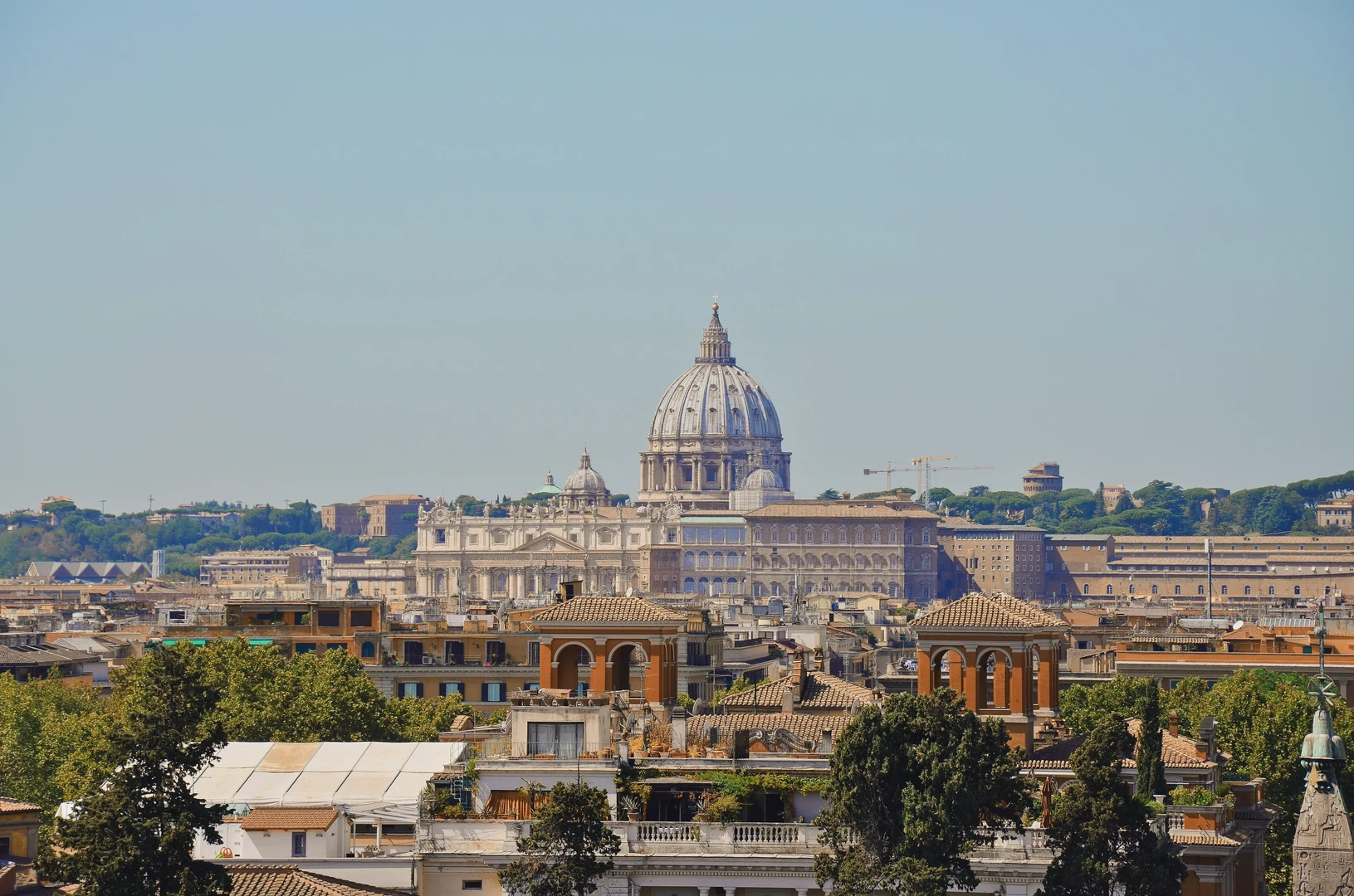 Eine Wissenschaftlerin und ein Wissenschaftler arbeiten hinter einer Glasfassade und mischen Chemikalien mit Großgeräten.