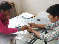 Researchers Franz Beyuma and Gabriel Supa observe the differences in the ceramic samples