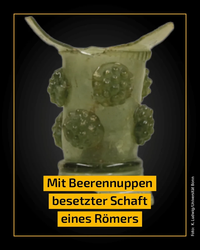 Eine Wissenschaftlerin und ein Wissenschaftler arbeiten hinter einer Glasfassade und mischen Chemikalien mit Großgeräten.