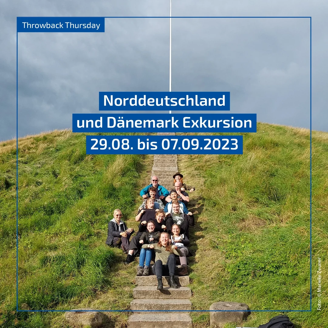 Eine Wissenschaftlerin und ein Wissenschaftler arbeiten hinter einer Glasfassade und mischen Chemikalien mit Großgeräten.