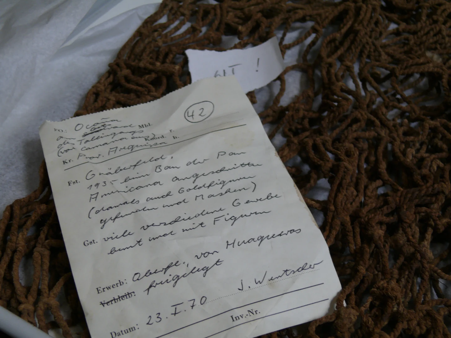 Eine Wissenschaftlerin und ein Wissenschaftler arbeiten hinter einer Glasfassade und mischen Chemikalien mit Großgeräten.